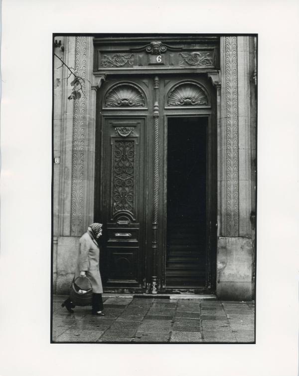 Woman with Basket Walking Past Doors, ca. 1970s