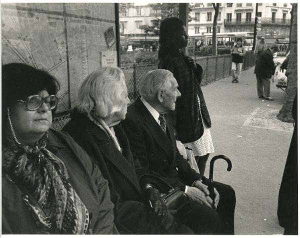 Black Woman Standing by Old People at Bench, ca. 1970s