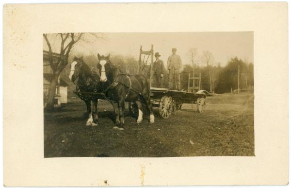 Two Men Standing on Horse Drawn Wagon