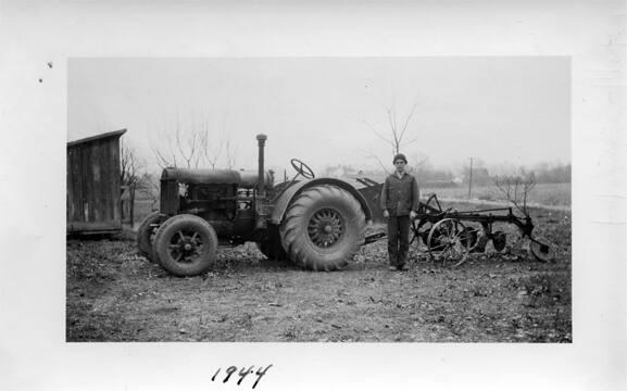 Boy Standing with 10-20 Tractor and a Plow