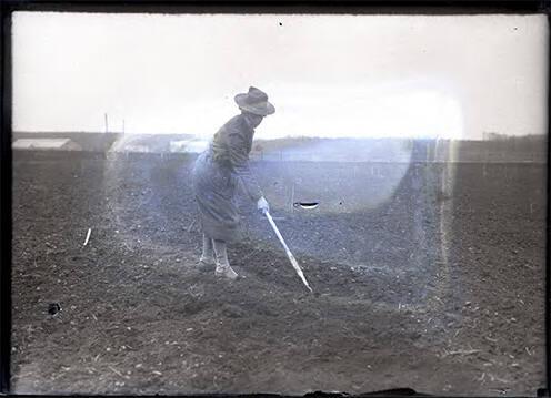 Woman Using a Hoe in a Field