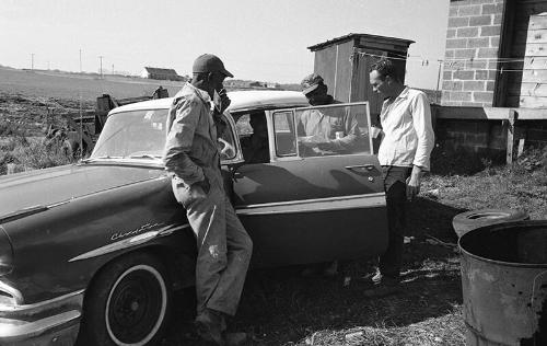 Men Stand  Around a Car