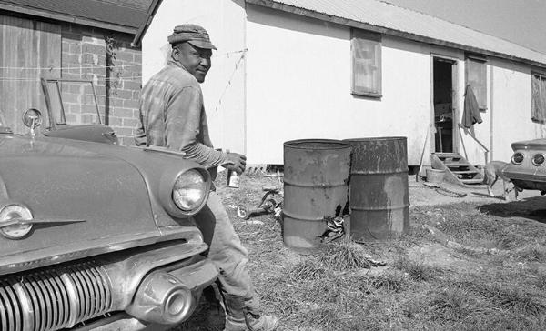 A Man Leans on a Car