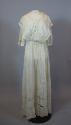 One-piece wedding dress of white cotton, seen from front. Bodice is made with two long pieces t…