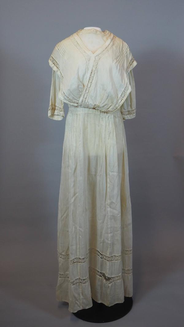 One-piece wedding dress of white cotton, seen from front. Bodice is made with two long pieces t…