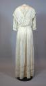 One-piece wedding dress of white cotton, seen from the back. Bodice is made with two long piece…