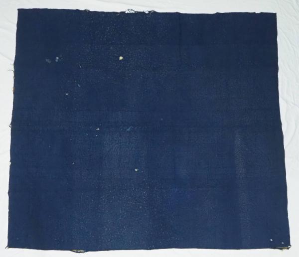 Whole-cloth quilt with dark blue wool top and light and dark brown wool back.