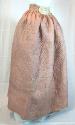 Photo of a pink silk quilted petticoat with a note attached to the wide waistband.