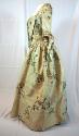 Fitted gown of brocaded silk, seen from the side.