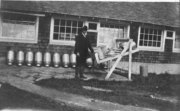 Man with milk pails and cans