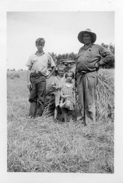 Two Children, a Man and Teenage Boy in a Hay Field