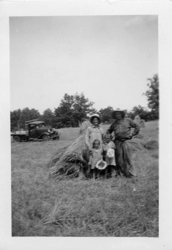 Two Children, a Man and Woman in a Hay Field