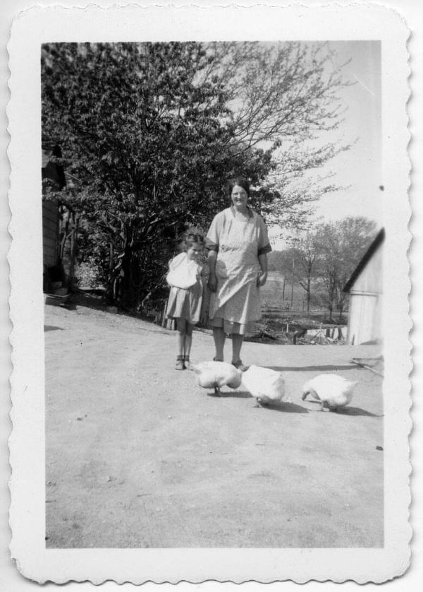 A Woman and Young Girl Pose with Three Birds