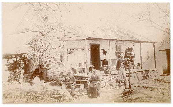 Two Men & A Woman Outside Cabin
