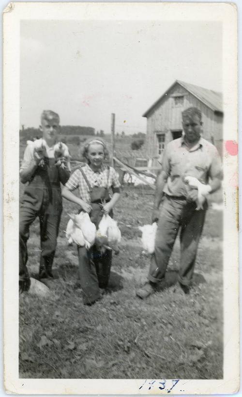 Three People Holding Chickens