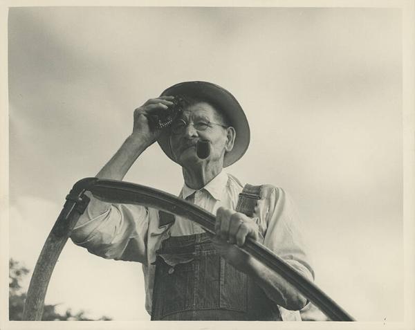 Man Stands with Scythe