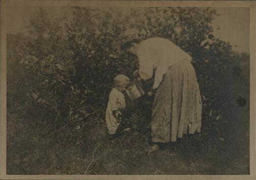 Toddler Drinking from a Small Pail