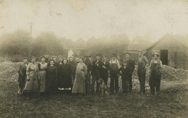A Group in Front of Piles of Apples