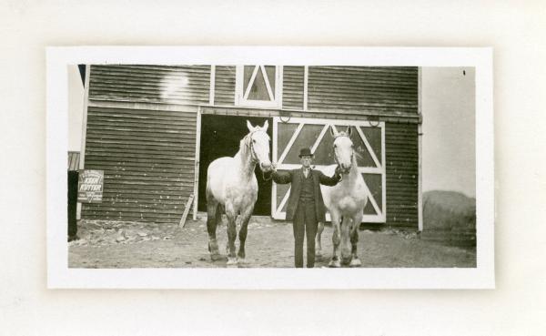 Man and Work Horses in Front of Barn