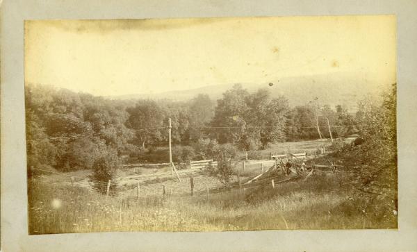 Two Men in a Field by Train Tracks