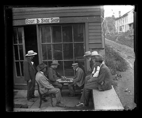 Men Playing Checkers outside the Boot & Shoe Shop