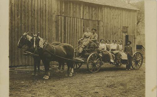 Two Men and Five Women Pose on Wagon