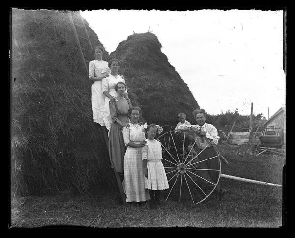 Family Posing with Large Stacks of Straw