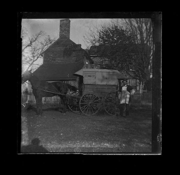 Man Stands Selling Near Wagon