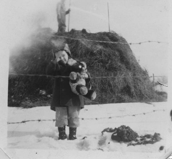 Boy In Front of Large Hay Stack