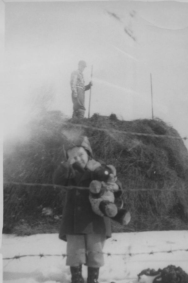 Boy In Front of Large Hay Stack